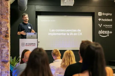 Javi González at the lectern beside the title slide, Las consecuencias de implementar la IA en CX, with the partner logos behind him.