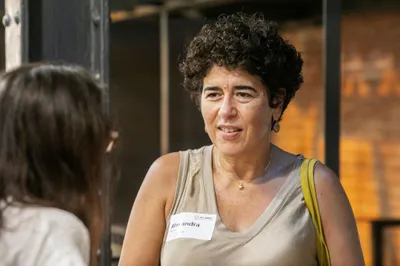 A guest with curly hair listening to someone during the networking.