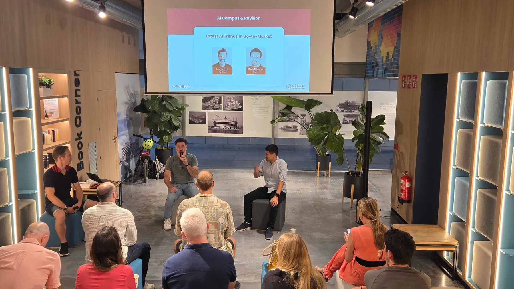 Audience at an AI Campus session watching a panel talk, presentation screen reading AI Campus & Pavilion.