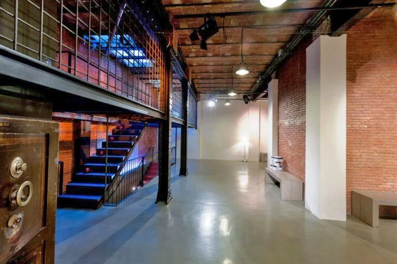 Industrial event hall with exposed brick, a mezzanine and staircase.